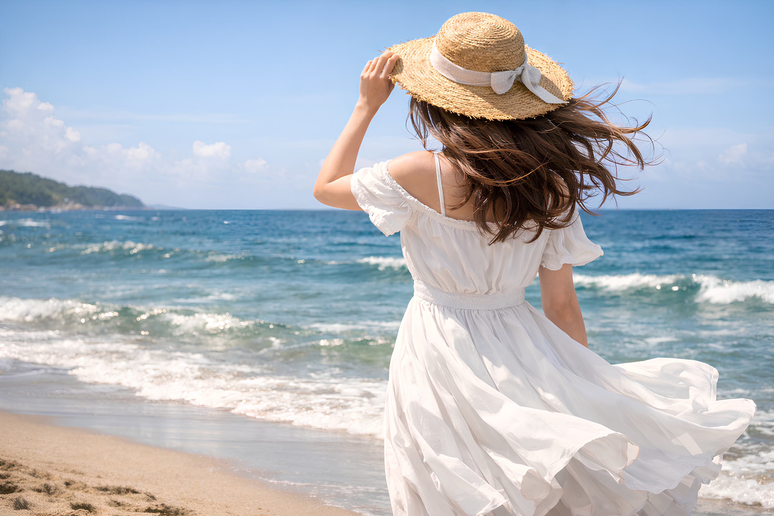 海辺で麦わら帽子をかぶり、白いロングスカート姿で風に髪をなびかせる後ろ姿